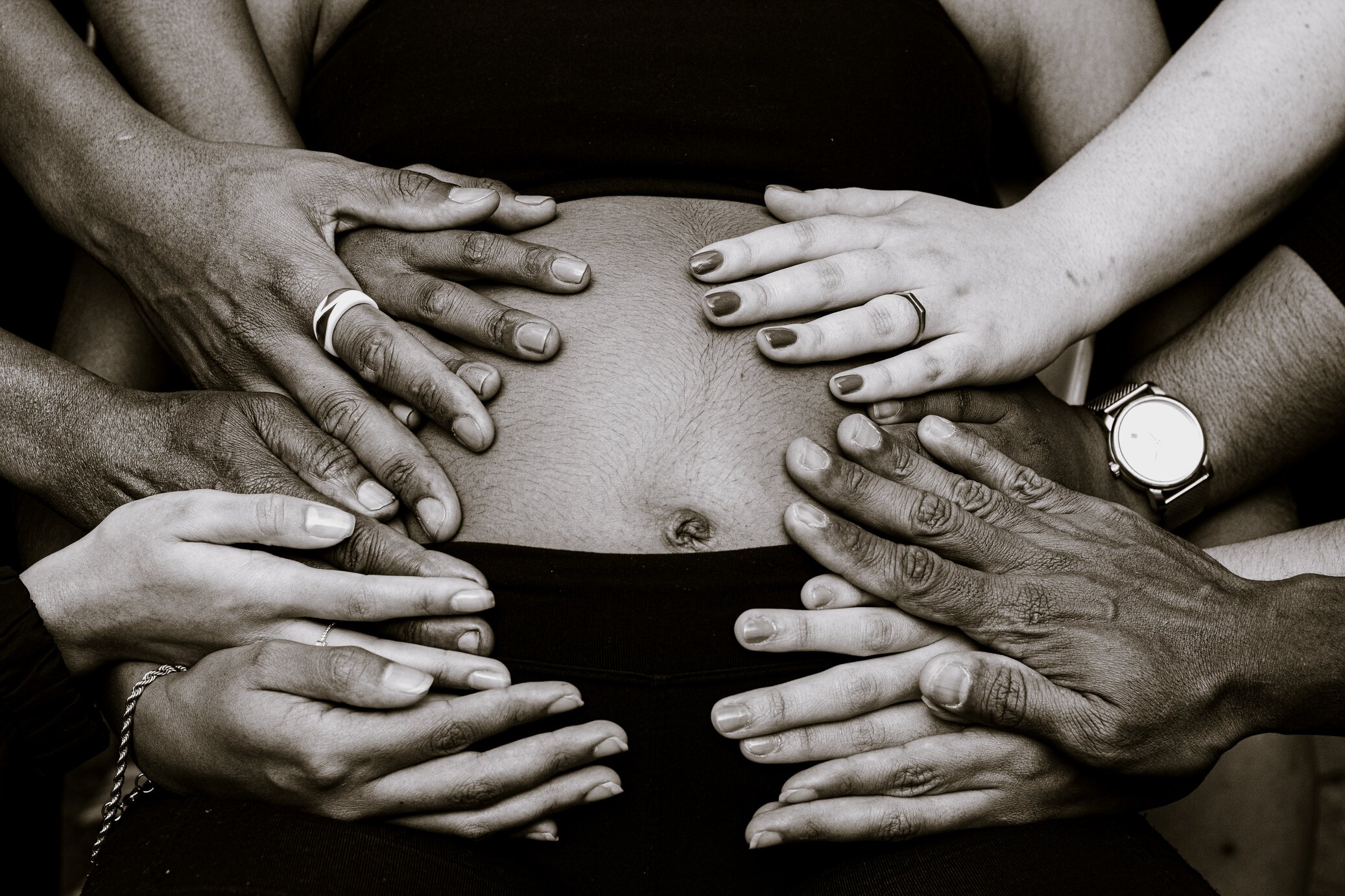 Unrecognizable people touching belly of crop pregnant woman